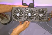 a person holding a computer fan in their hand